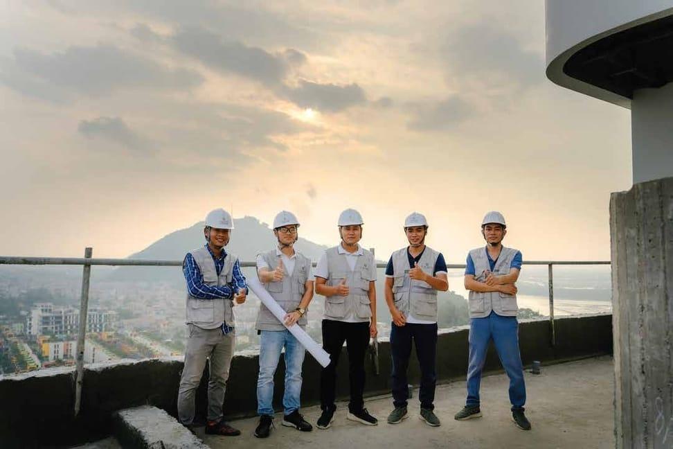 Bảng suất vốn đầu tư xây dựng khách sạn theo hạng sao 4 Đội ngũ kỹ sư Romo Cons đứng trên sàn bê tông tầng cao của công trình khách sạn đang thi công